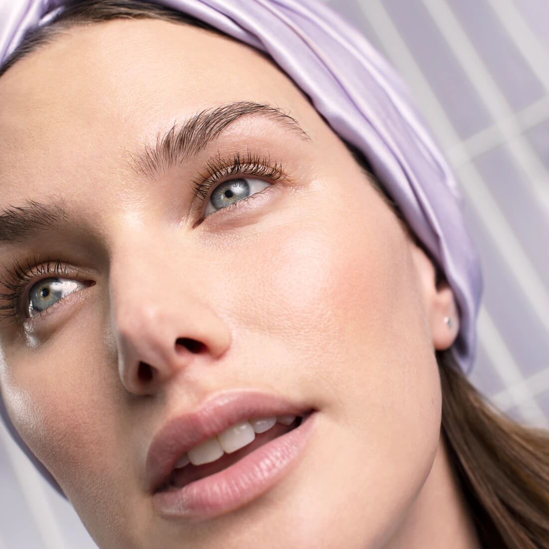 Closeup of woman wearing hair wrap with clean, hydrated skin