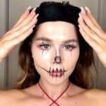 Young woman with black Halloween makeup demonstrating a Halloween skincare routine