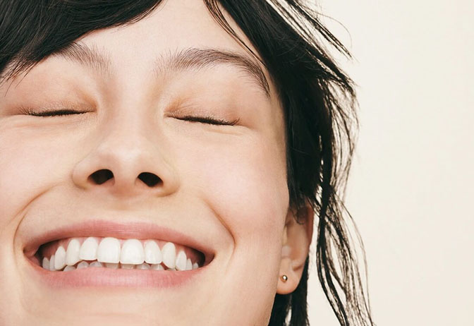 Woman without makeup smiling with eyes closed. Woman without makeup smiling with eyes closed.