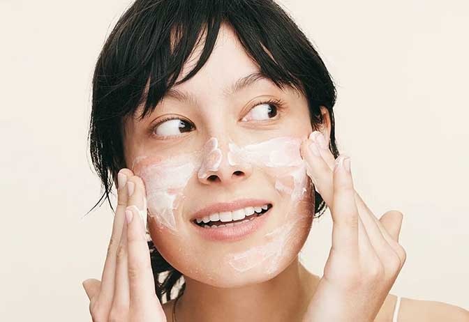 Woman applying face product. Woman applying face product.